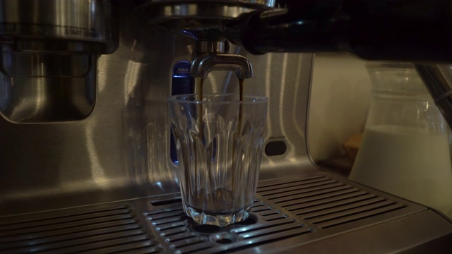 浓缩咖啡从咖啡机倒出来的特写。专业的咖啡酿造视频下载