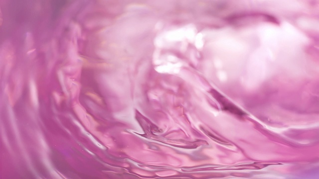 吹淡粉色的水面和制造涟漪和波浪，在近距离和慢动作视频素材