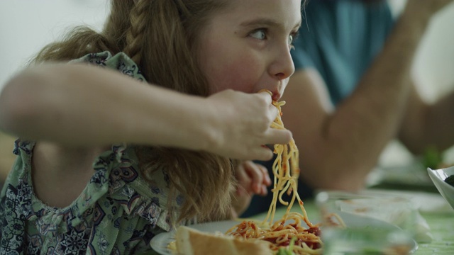顽皮凌乱的女孩用手吃意大利面的特写/ Lehi，犹他州，美国视频下载