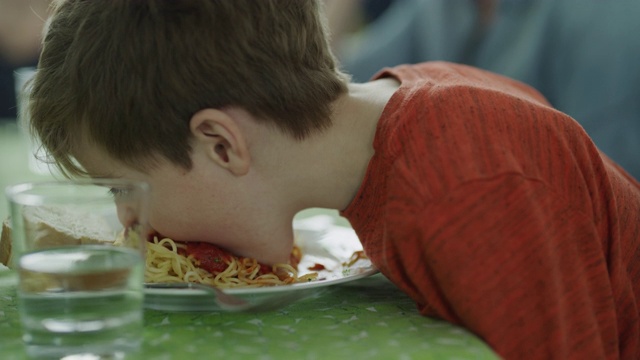 顽皮的凌乱男孩吃意大利面和摇头的特写/ Lehi，犹他州，美国视频下载