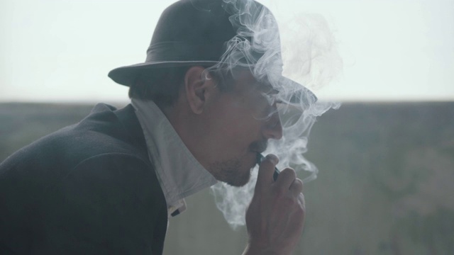 一个成功自信的吸烟男人的肖像，穿着时尚的复古西装。视频素材