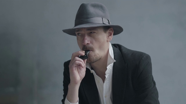 一个成功自信的吸烟男人的肖像，穿着时尚的复古西装。视频下载