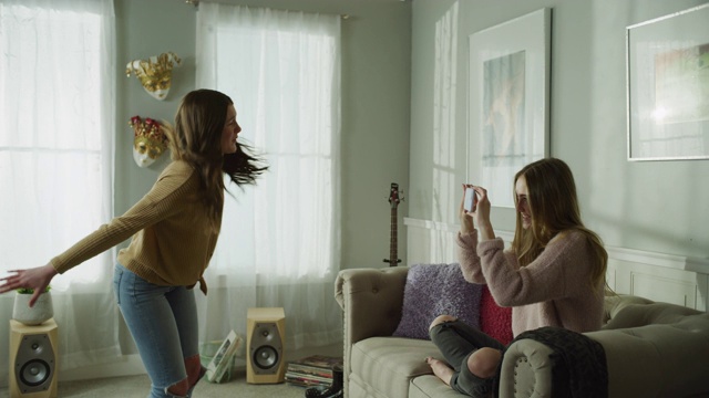 美国犹他州雪松山，女孩用手机录下姐姐在客厅跳舞的画面视频下载