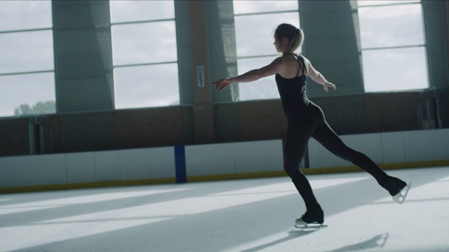 远处女子在溜冰场练习花样滑冰的慢动作/默里，犹他州，美国视频素材