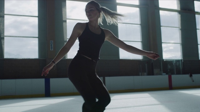 慢动作低角度观看女子在溜冰场上练习花样滑冰/默里，犹他州，美国视频素材