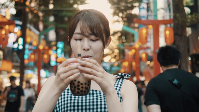 年轻的亚洲女子在西门町购物区喝珍珠奶茶视频下载