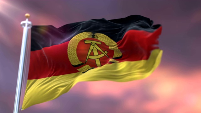 日落时飘扬的德意志民主共和国或东德国旗。循环视频下载