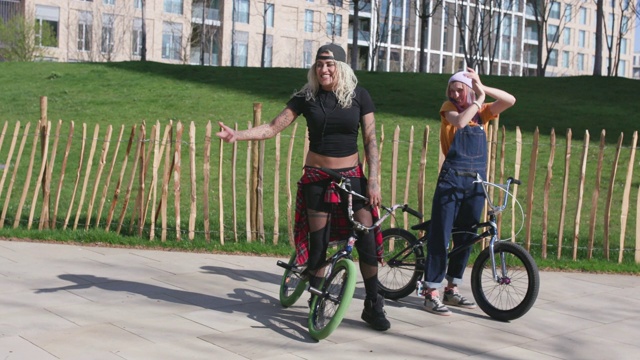 年轻女性在现代城市环境中骑小轮车视频下载