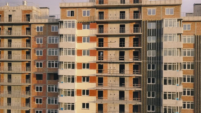 正在建设中的住宅公寓建筑的外立面鸟瞰图。有窗户和阳台的高层建筑。建筑行业。城市化视频下载