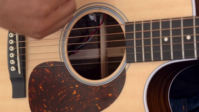 一个年轻人弹拨和挑选一个原声吉他的视频剪辑视频下载