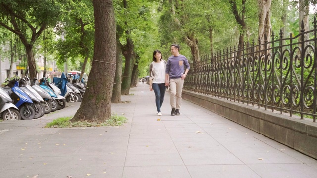 台湾台北市一对年轻夫妇走在人行道上视频素材
