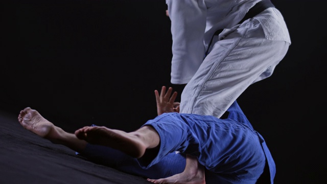 SLO MO男性柔道运动员在白色的服装扔他的对手在地上视频素材