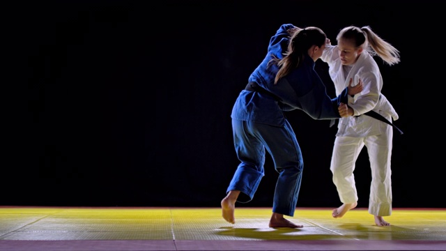 两个女柔道运动员在榻榻米上打架视频素材
