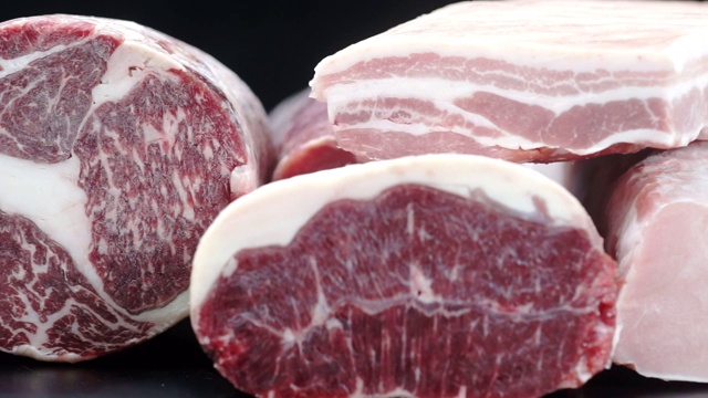 将9夹不同类型的新鲜生猪肉和牛肉放在厨房昏暗的桌子上切片。视频素材