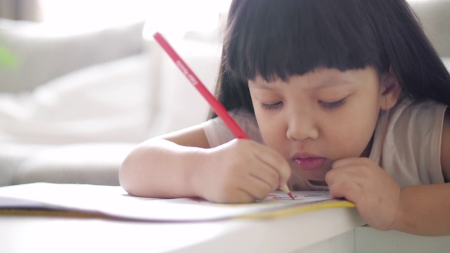 小女孩在学校的画册上写字，慢镜头视频素材