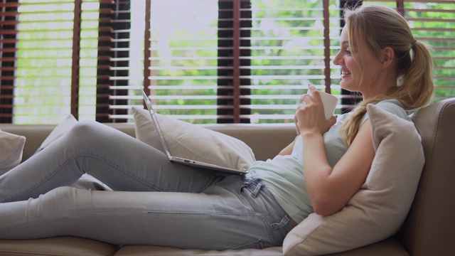 坐在沙发上喝咖啡的女人视频素材