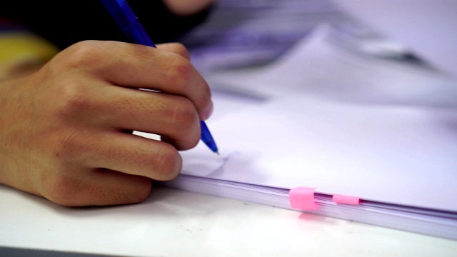 文件报告和业务繁忙的概念:商人经理手握蓝色钢笔阅读和签署文件或文件文件的电脑现代公司办公背景。视频素材