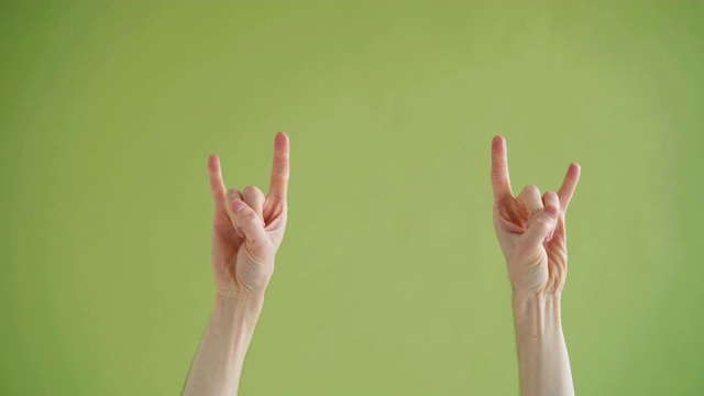 人的手做v手势的特写镜头在绿色的背景跳舞视频素材
