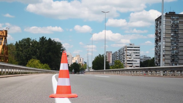 街道上橙色的交通安全锥形路障保护着柏油路驾驶车道上的白色油漆视频素材