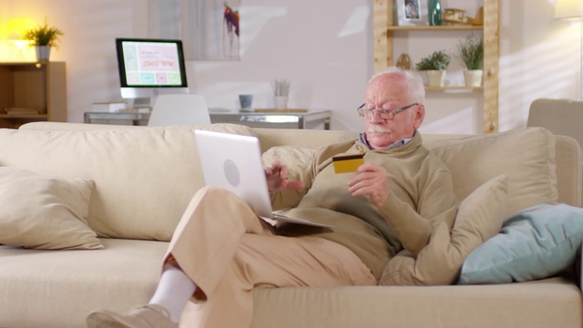 戴眼镜的老人在网上购物视频素材