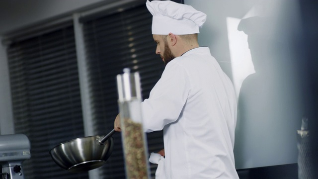 男厨师在厨房的锅里做饭。专注于制作亚洲美食的厨师视频下载