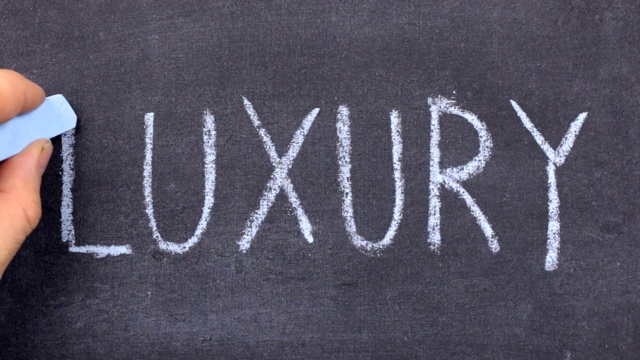 奢侈字，用粉笔手写在黑板上。视频素材