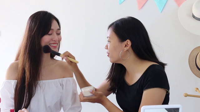 两个美丽的亚洲女人博客展示如何化妆和使用化妆品。在摄像机前录制在家的视频直播。商业在线影响者对社交媒体的概念。视频素材