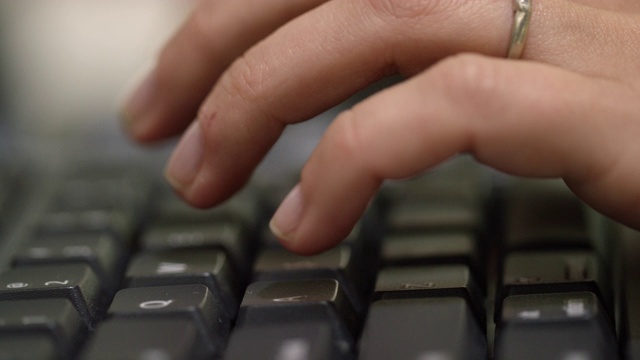 一个已婚白人女人的手在电脑键盘上打字的特写视频素材