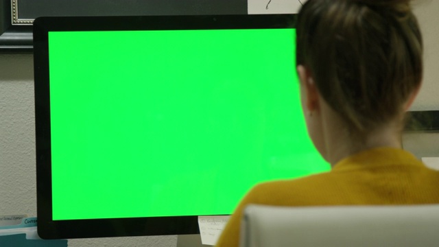 一位三十多岁的白人妇女在家庭办公室里摆弄电脑(绿屏)视频下载