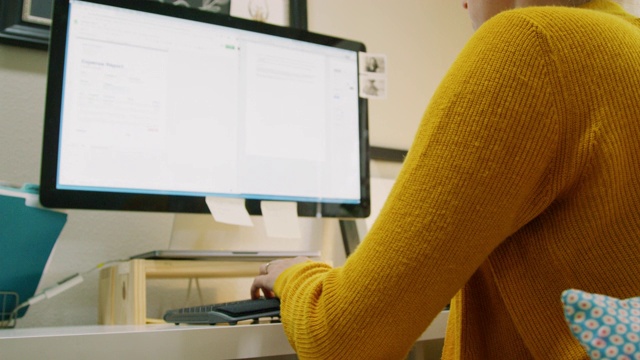 一位三十多岁的白人妇女在室内家庭办公室里用电脑工作视频素材