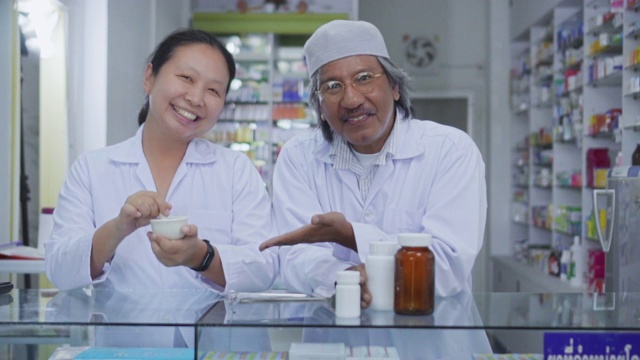 两名药剂师在药房自信微笑的肖像，慢镜头视频下载