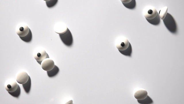 眼睛形状的糖果跳舞在白色的背景在慢动作视频下载