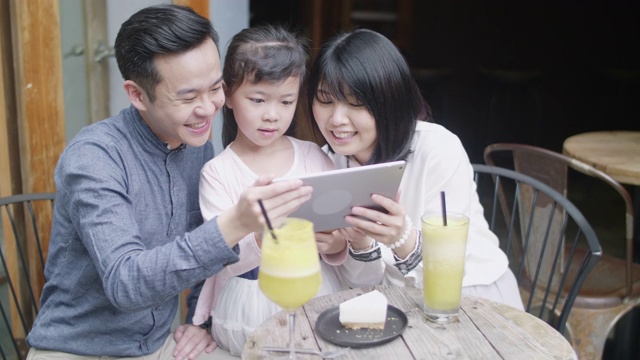 年轻的台湾父母花时间与女儿在咖啡馆视频素材