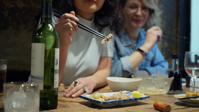 两个女人在酒吧用筷子吃饭视频素材