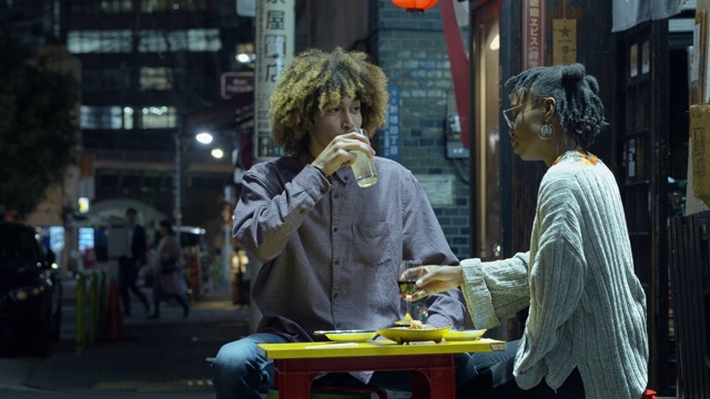 东京，一名年轻女子在户外餐厅给男友喂食物视频素材