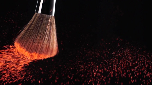 慢动作:化妆刷在黑色背景上涂抹腮红粉视频素材