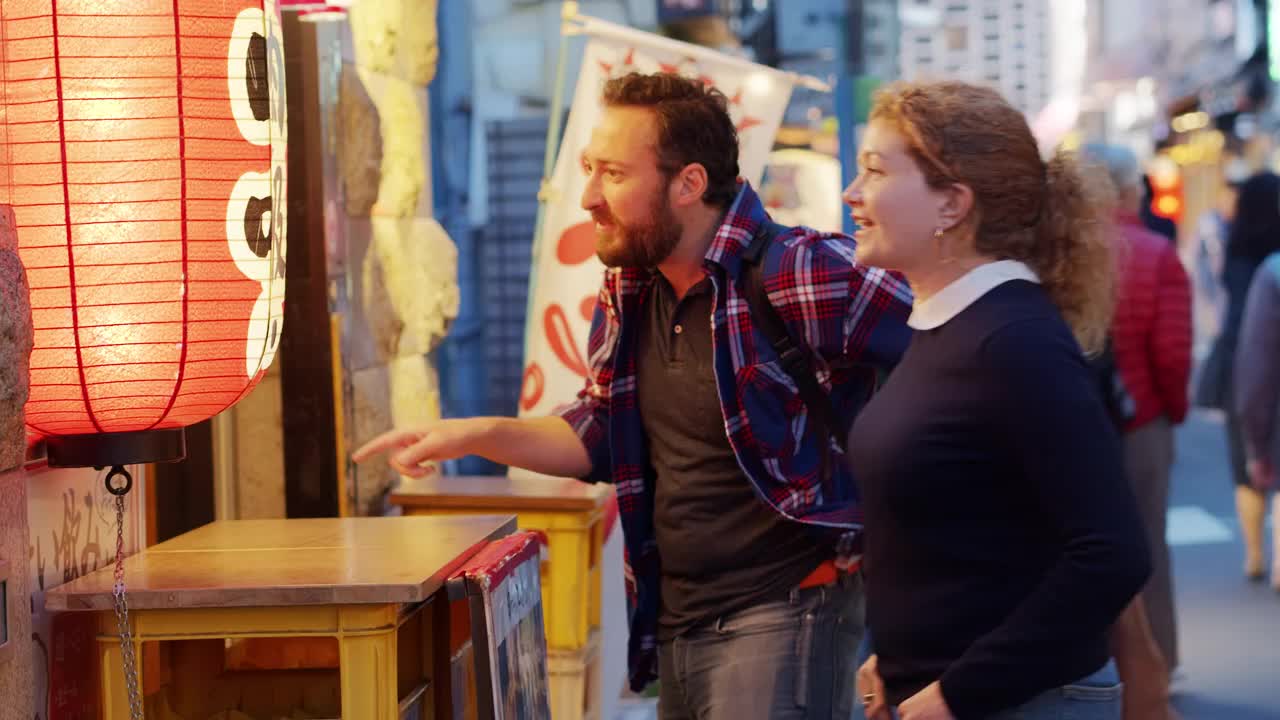 东京，白人游客在餐馆外看菜单视频素材