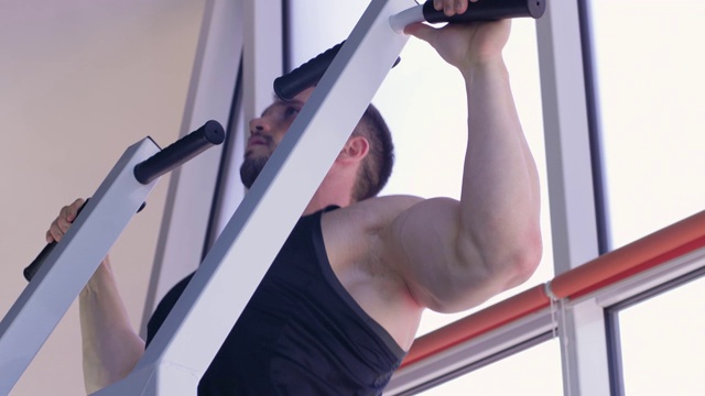 运动训练，强壮的健美者与美丽的运动身体拉上模拟器在健身房的力量锻炼视频下载