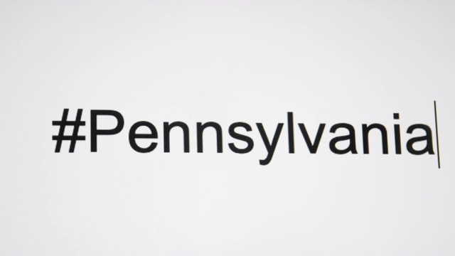 一个人在电脑屏幕上输入“#Pennsylvania”，然后是州的缩写视频下载