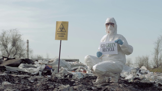 生物危害应急，危险品生物学家进入防护服装显示标志去绿色回收在垃圾场与指针生物危害视频下载