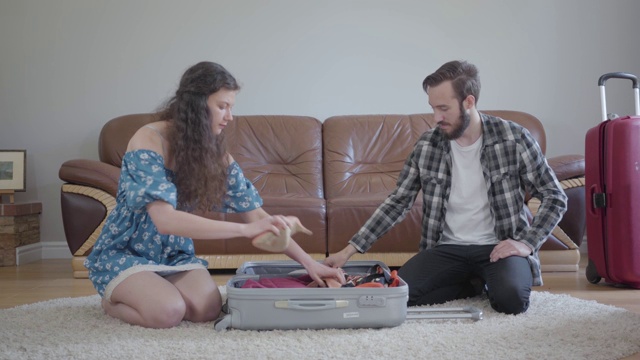 一幅男人和女人坐在家里皮沙发前地板上的肖像视频素材