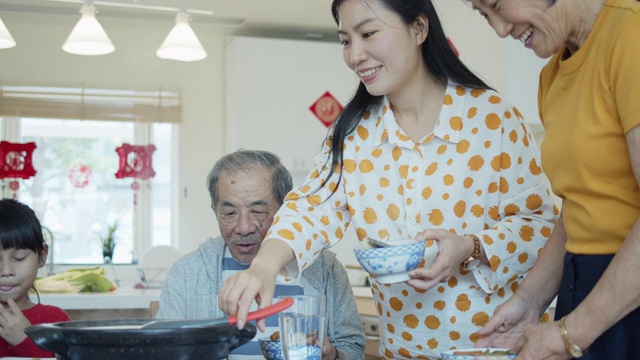 家庭成员在中国新年聚餐时互相服务的慢蛾镜头视频素材