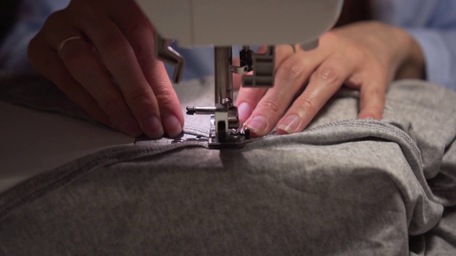 女人用缝纫机缝东西的手。女人的手在缝纫机上缝纫。时尚、创意、剪裁。视频素材