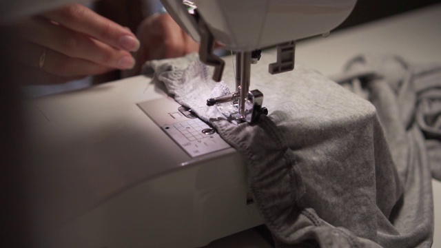用缝纫机缝纫的女人的手。女人的手在缝纫机上缝东西。时尚、创作和剪裁。视频素材