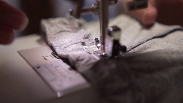 用缝纫机缝纫的女人的手。女人的手在缝纫机上缝东西。时尚、创作和剪裁。视频素材