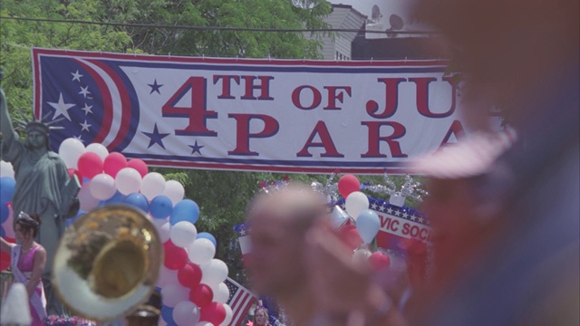 七月四日的游行。花车、气球、拉拉队、装饰品、横幅和旗帜。一大群人。视频下载