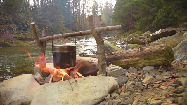 在篝火上用锅煮食物视频素材