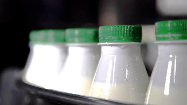 装牛奶的塑料瓶在自动化生产线上运输。近距离视频下载