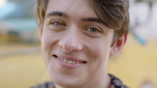 一个戴鼻环的年轻人对着镜头微笑。视频下载
