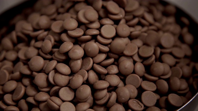 将巧克力倒入碗中进行回火。工厂糖果生产技术视频下载